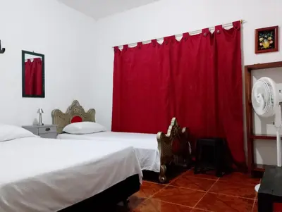 a bedroom with a bed with a red curtain at Brisas del Río in Honda