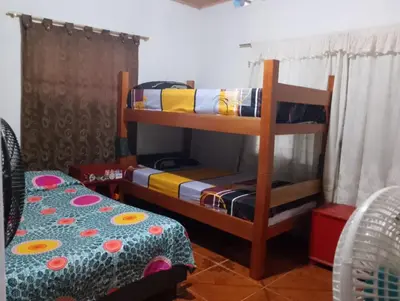 a bedroom with a bunk bed and a table at Brisas del Río in Honda