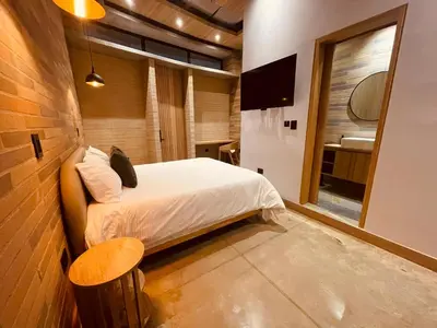 a bedroom with a bed and a table and a mirror at Hotel Boutique Obelisco in Medellín