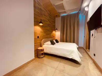 a bedroom with a bed and a wooden wall at Hotel Boutique Obelisco in Medellín