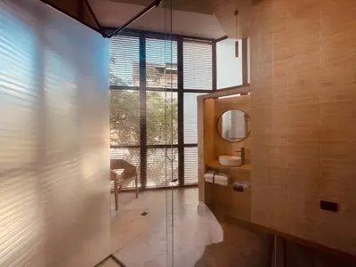 a bathroom with a glass shower and a mirror at Hotel Boutique Obelisco in Medellín