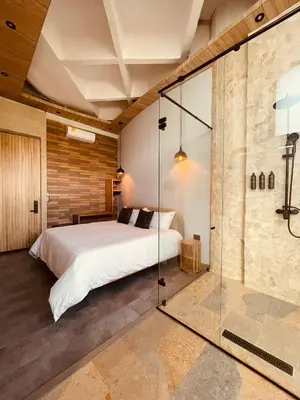 a bedroom with a bed and a glass shower at Hotel Boutique Obelisco in Medellín