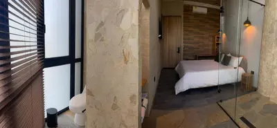 a bedroom with a bed and a glass wall at Hotel Boutique Obelisco in Medellín