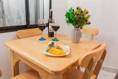 a wooden table with a plate of fruit and wine glasses at Aptos Familiares en Envigado con Aire Acondicionado in Envigado
