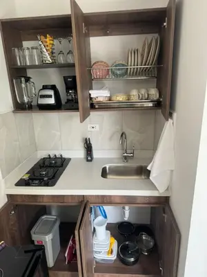 a small kitchen with a sink and a stove at 24 Laureles Prime Elegancia y Comodidad Medellín in Medellín