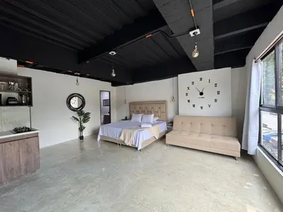 a bedroom with a bed and a clock on the wall at 24 Laureles Prime Elegancia y Comodidad Medellín in Medellín