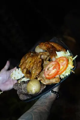 a person holding a plate of food with a sandwich at San Sebastián barbosa in Barbosa