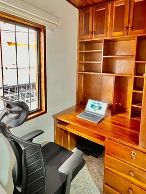 an office with a desk with a laptop on it at Amplio apto 2 hab para familias y grupos Sabaneta in Sabaneta