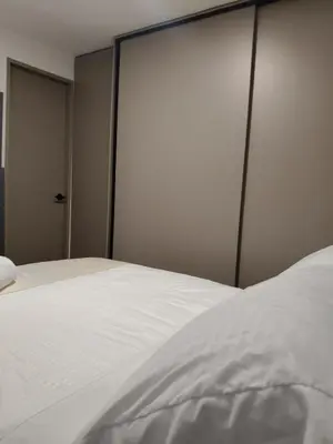 a bedroom with a white bed with a sliding door at Confortable Apartamento cerca Aeropuerto JMC unidad Cerrada in Rionegro