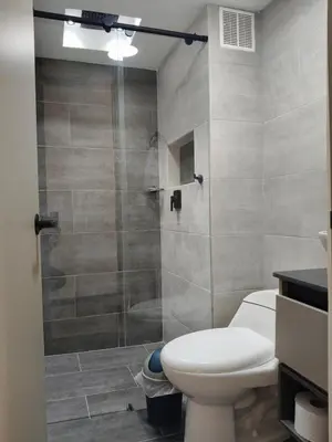 a bathroom with a toilet and a glass shower at Confortable Apartamento cerca Aeropuerto JMC unidad Cerrada in Rionegro