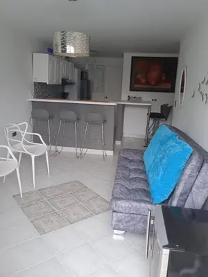a living room with a couch and a kitchen at Apartamento vista lago 202 in Guatapé