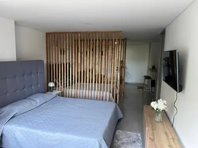 a bedroom with a blue bed and a television at Apartamento Living La Ceja in La Ceja
