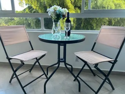 two chairs and a table with a vase and a bottle of wine at Apartamento Living La Ceja in La Ceja