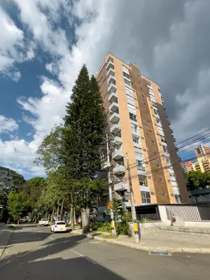 a tall building with a tree in front of it at Vegas PH Suites in Medellín