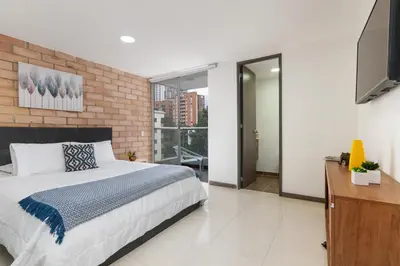 a bedroom with a large bed and a television at Vegas PH Suites in Medellín