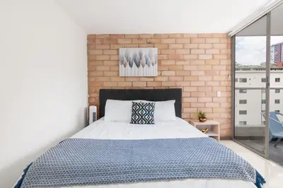 a bedroom with a bed and a brick wall at Vegas PH Suites in Medellín