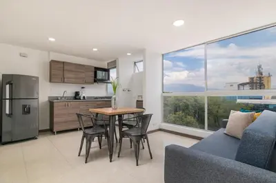 a kitchen and living room with a table and chairs at Vegas PH Suites in Medellín