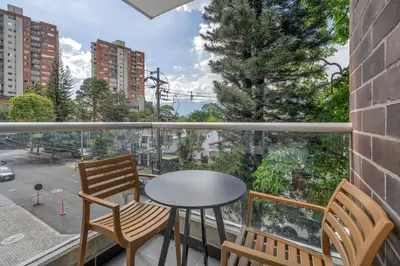 a balcony with a table and chairs and a view of a street at Vegas PH Suites in Medellín