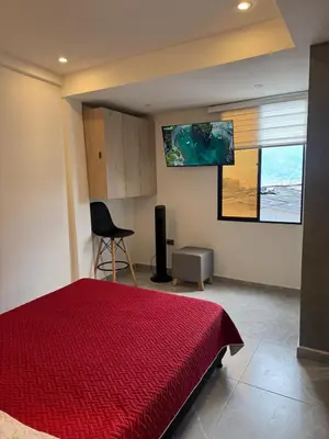 a bedroom with a bed with a red bedspread at Villa Loreto Aparta estudio 301 in Medellín