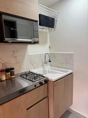 a kitchen with a sink and a microwave at Villa Loreto Aparta estudio 301 in Medellín