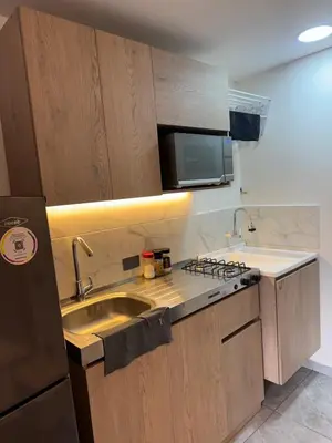 a small kitchen with a sink and a microwave at Villa Loreto Aparta estudio 301 in Medellín