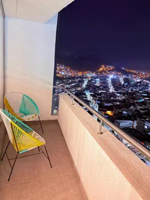 a balcony with a view of a city at night at Apartamento moderno con balcón y vista a la ciudad cerca al mall plaza in Manizales