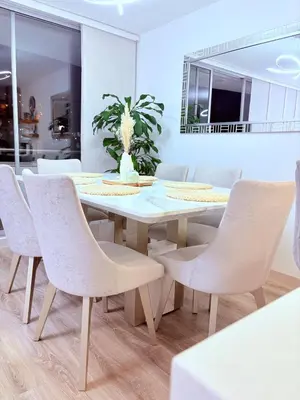 a dining room with a white table and chairs at Apartamento moderno con balcón y vista a la ciudad cerca al mall plaza in Manizales
