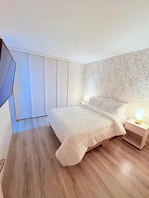 a bedroom with a large bed and a tv at Apartamento moderno con balcón y vista a la ciudad cerca al mall plaza in Manizales
