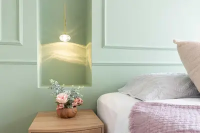 a vase with flowers on a table next to a bed at Exclusive Luxury Apartment - Poblado Medellín in Medellín