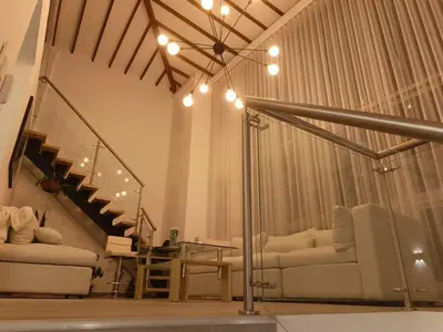 a living room with two couches and a staircase at Penthouse with Jacuzzi in Guarne in Guarne