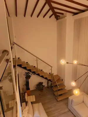 a living room with a staircase and a couch at Penthouse with Jacuzzi in Guarne in Guarne