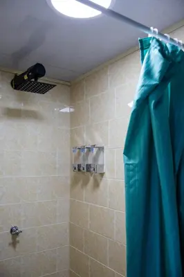 a shower with a blue shower curtain in a bathroom at S23 I City Lodge in Sabaneta