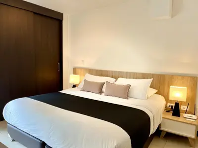 a bedroom with a large white bed with two lamps at Suites - Llanogrande in Rionegro