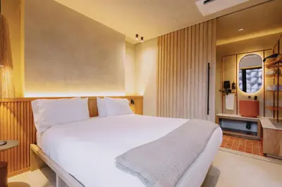 a bedroom with a large white bed and a window at Kuuna Medellín By Be Host in Medellín