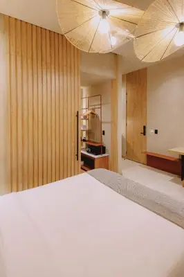 a bedroom with a large white bed and two lights at Kuuna Medellín By Be Host in Medellín