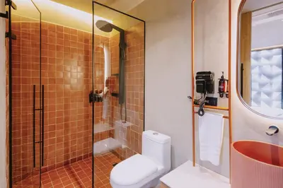 a bathroom with a toilet and a glass shower at Kuuna Medellín By Be Host in Medellín