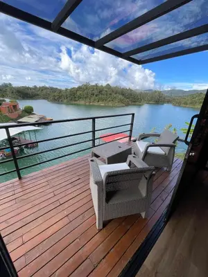 a deck with chairs and a view of a river at Boreal Glamping in Guatapé