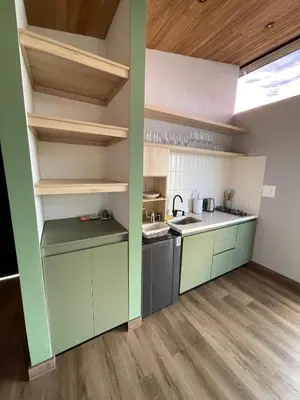 a kitchen with green and white walls and wooden floors at Boreal Glamping in Guatapé