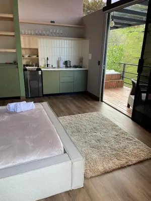 a large bedroom with a bed and a kitchen at Boreal Glamping in Guatapé