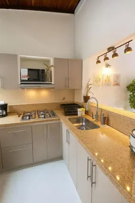 a kitchen with a sink and a microwave at Casa Bosques in Pilarica - Family and cozy in Medellín