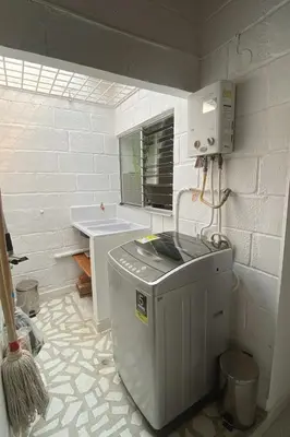 a bathroom with a washing machine and a sink at Casa Bosques in Pilarica - Family and cozy in Medellín