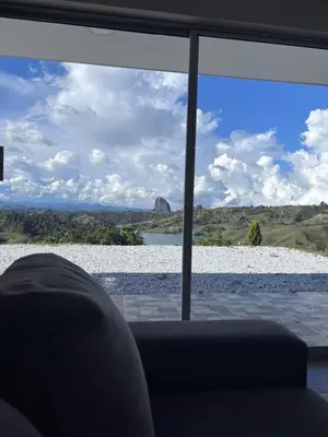 a room with a view of a lake through a window at Finca El Encanto Guatapé in Guatapé