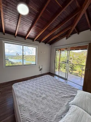 a bedroom with a large bed with a large window at Finca El Encanto Guatapé in Guatapé