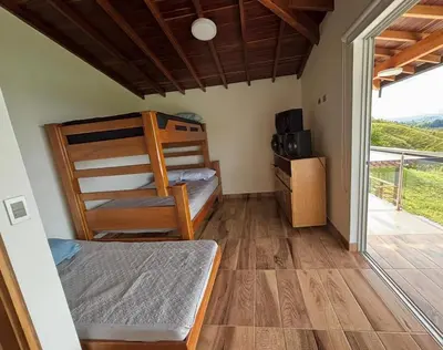 a bedroom with a bunk bed and a balcony at Finca El Encanto Guatapé in Guatapé