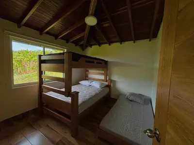 a small bedroom with a bunk bed and a window at Finca El Encanto Guatapé in Guatapé