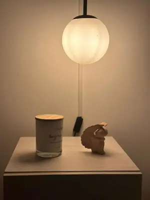 a table with a lamp and a candle and a cup at Plaza Corales Manizales in Manizales
