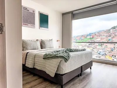 a bedroom with a bed and a large window at Plaza Corales Manizales in Manizales