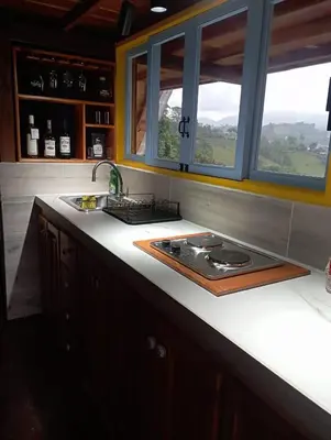 a kitchen counter with a sink and a stove at Cabaña El Jericoano in Jericó