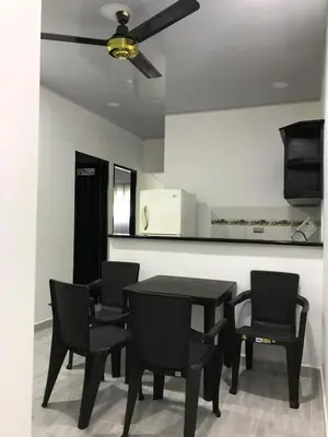 a dining room with a black table and chairs at Apartahotel in Doradal