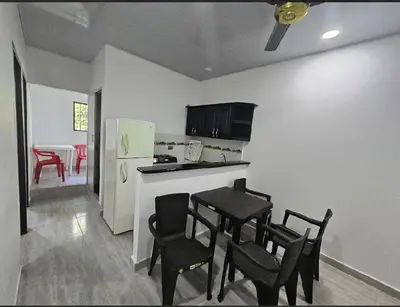a kitchen with a table and chairs and a refrigerator at Apartahotel in Doradal